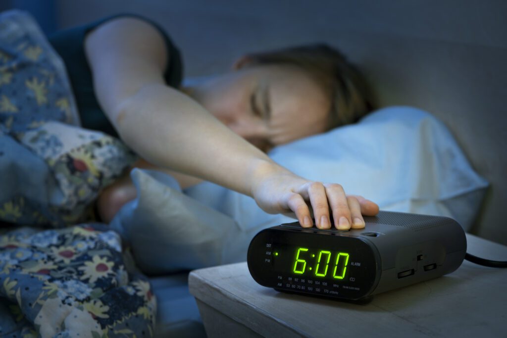 A woman is sleeping in bed with her head on the table